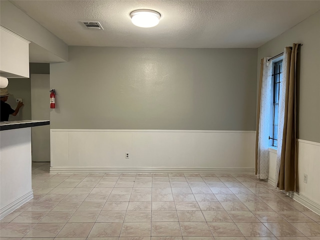 unfurnished room with a textured ceiling