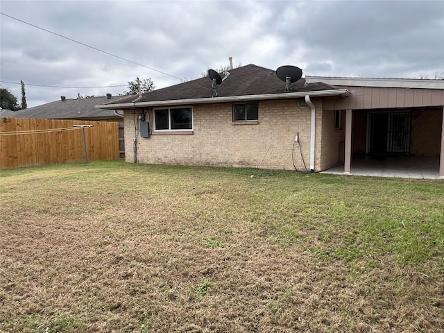 back of property featuring a lawn and a patio