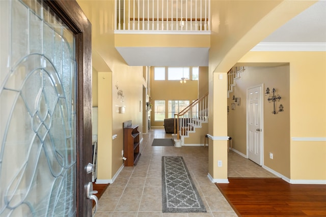 entrance foyer with hardwood / wood-style floors, a high ceiling, and crown molding