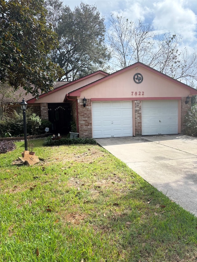 single story home featuring a garage and a front yard