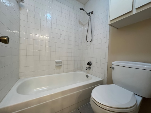 bathroom featuring tiled shower / bath, tile patterned floors, and toilet