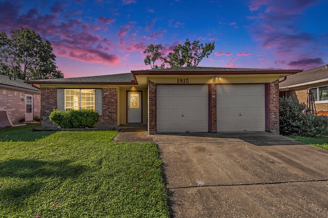 single story home with a garage and a lawn