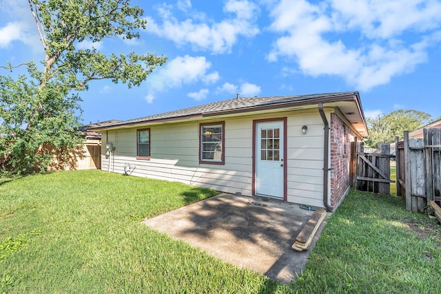 back of house with a lawn and a patio area