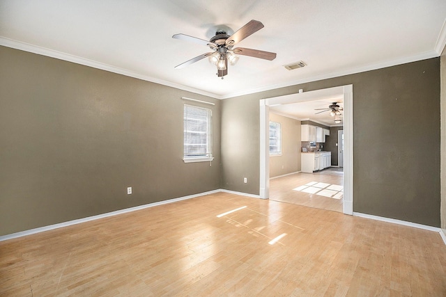 empty room with ceiling fan, light hardwood / wood-style floors, and crown molding