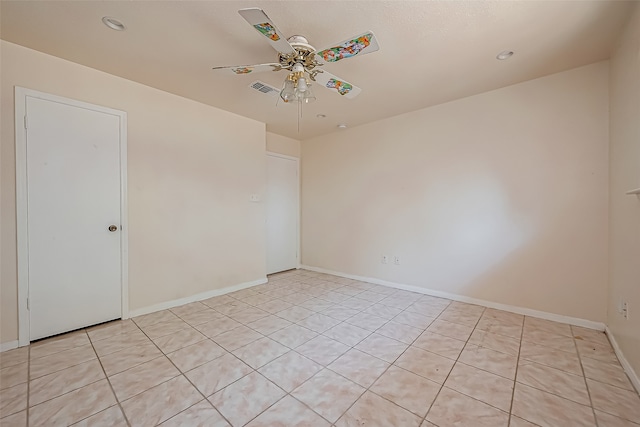 tiled spare room with ceiling fan