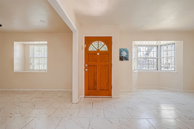 entrance foyer featuring plenty of natural light and a textured ceiling