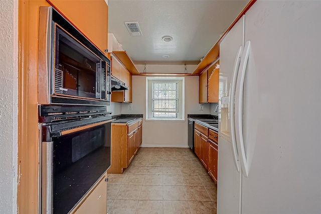 kitchen with black appliances, a textured ceiling, and light tile patterned floors