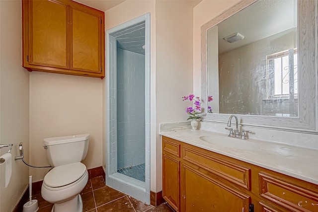 bathroom with vanity, walk in shower, tile patterned floors, and toilet