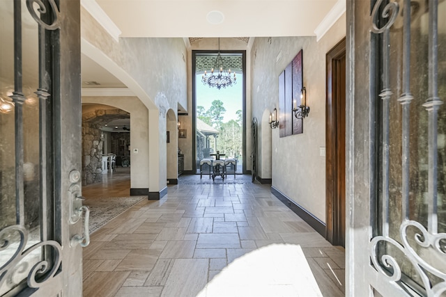 entrance foyer with a notable chandelier and crown molding