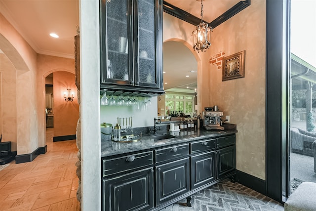 bar featuring dark stone countertops, sink, and ornamental molding