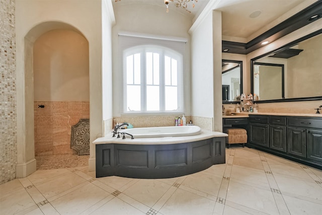 5015 Ossineke Ct, Spring, TX 77386 - bathroom featuring a bath, a wainscoted wall, vanity, inlaid floor details, and vaulted ceiling
