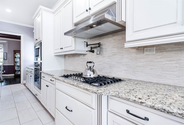 kitchen featuring decorative backsplash, light stone countertops, stainless steel appliances, crown molding, and white cabinetry