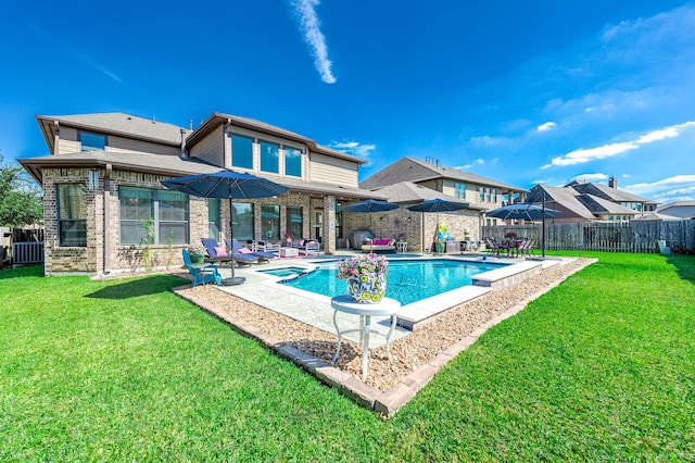 back of property featuring a fenced in pool, a yard, and a patio