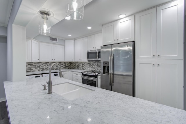 kitchen featuring white cabinets, stainless steel appliances, sink, and pendant lighting