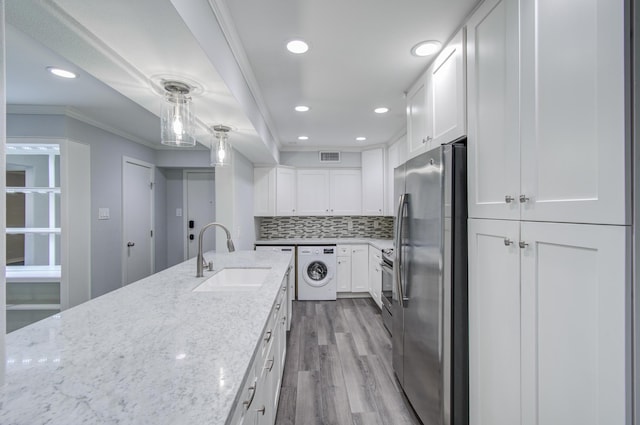 kitchen with white cabinetry, sink, light stone countertops, stainless steel refrigerator with ice dispenser, and washer / dryer