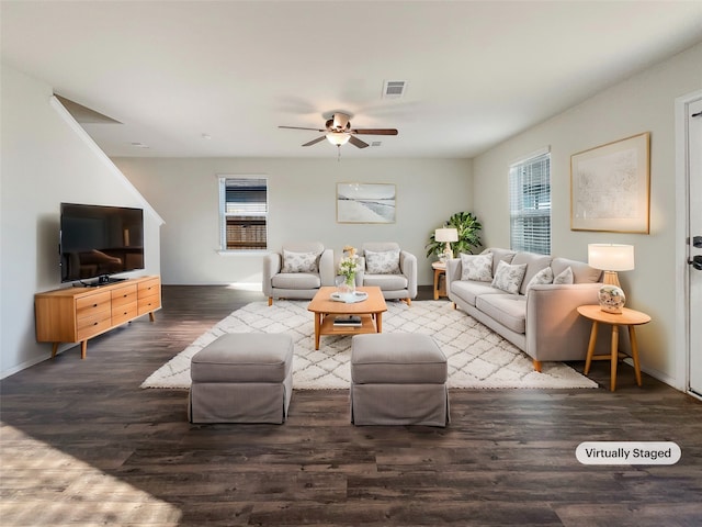 living room featuring dark wood-type flooring, ceiling fan, and a healthy amount of sunlight