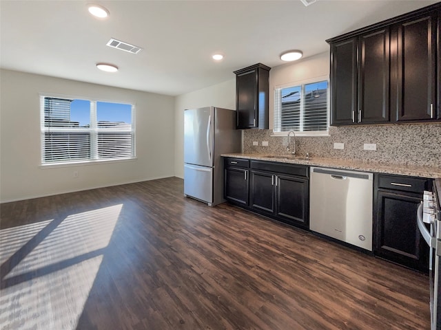 kitchen featuring stainless steel appliances, sink, decorative backsplash, and dark hardwood / wood-style flooring