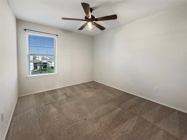 empty room featuring dark colored carpet and ceiling fan