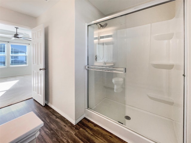 bathroom featuring hardwood / wood-style flooring, ceiling fan, and a shower with door