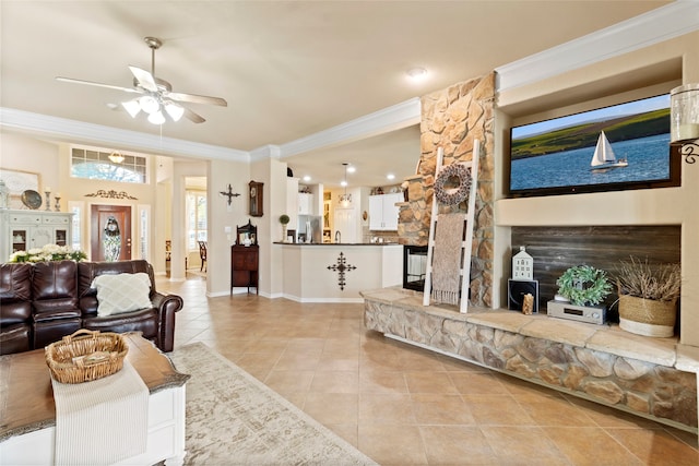 tiled living room with a fireplace, ceiling fan, and ornamental molding