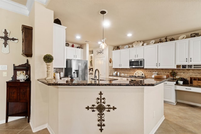 kitchen with white cabinetry, appliances with stainless steel finishes, decorative backsplash, and hanging light fixtures