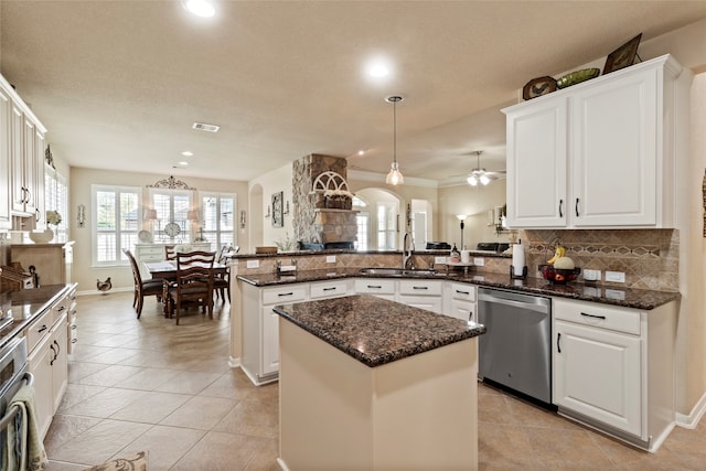 kitchen featuring dishwasher, kitchen peninsula, sink, a kitchen island, and decorative light fixtures