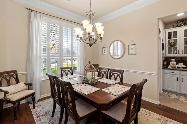 dining space featuring ornamental molding, a wealth of natural light, dark wood-type flooring, and a chandelier