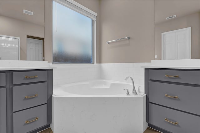 bathroom with vanity and a washtub