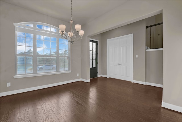 interior space with a wealth of natural light, dark hardwood / wood-style flooring, and a notable chandelier