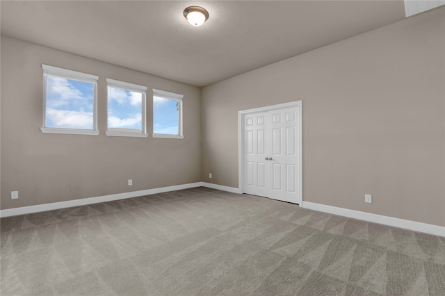 unfurnished bedroom with light colored carpet and a closet