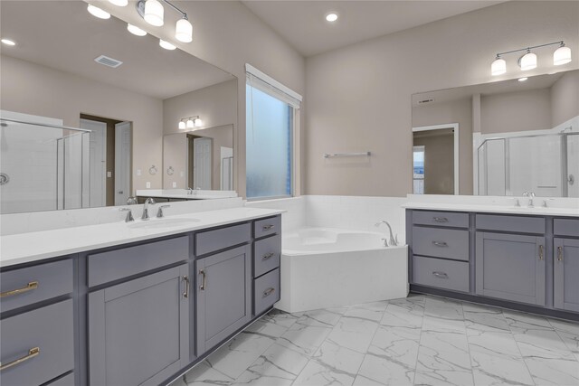 bathroom with a wealth of natural light, vanity, and separate shower and tub