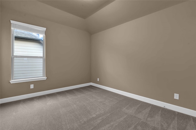 spare room featuring vaulted ceiling and carpet floors