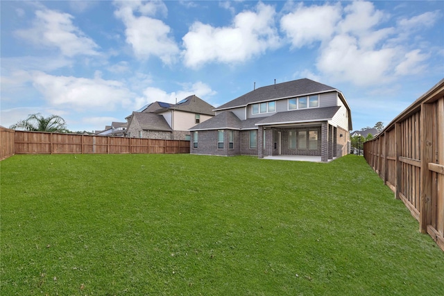 back of house with a patio area and a lawn