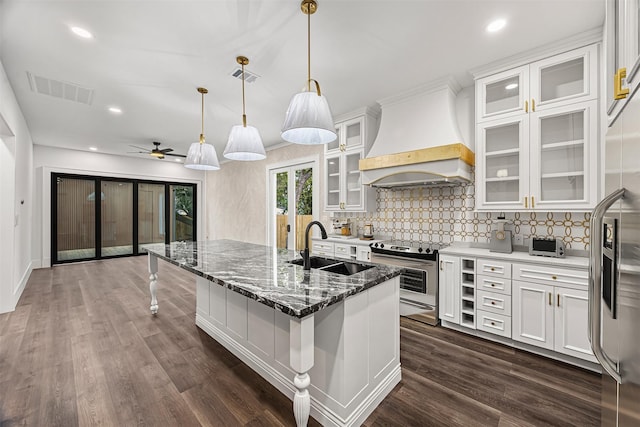 2714 Hardy St, Houston, TX 77009 - kitchen featuring stainless steel appliances, custom range hood, backsplash, white cabinets, and a breakfast bar