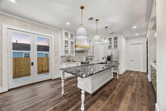 2714 Hardy St, Houston, TX 77009 - kitchen with french doors, white cabinetry, stainless steel fridge with ice dispenser, an island with sink, and recessed lighting
