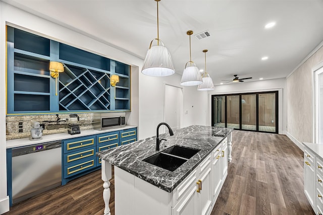 kitchen featuring an island with sink, ceiling fan, stainless steel appliances, white cabinets, and sink