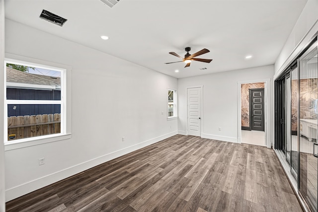 unfurnished bedroom with ceiling fan, wood-type flooring, and multiple windows