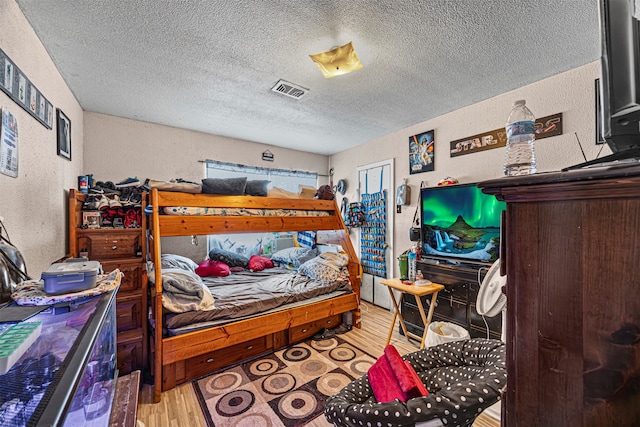 bedroom featuring hardwood / wood-style floors and a textured ceiling