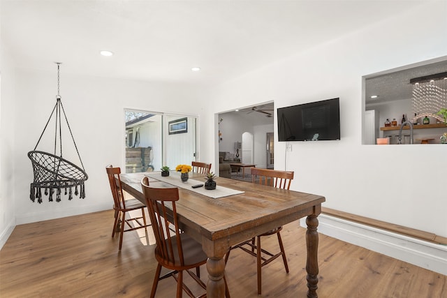 dining area with sink, wood-type flooring, and ceiling fan