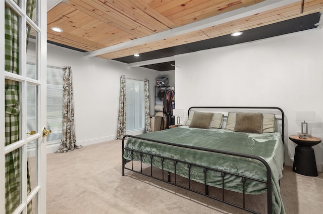 bedroom with beamed ceiling, wooden ceiling, and light colored carpet