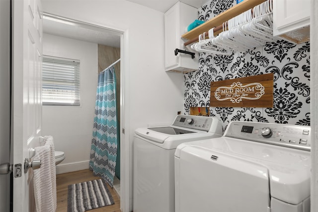 laundry room with wood-type flooring, cabinets, and washing machine and clothes dryer