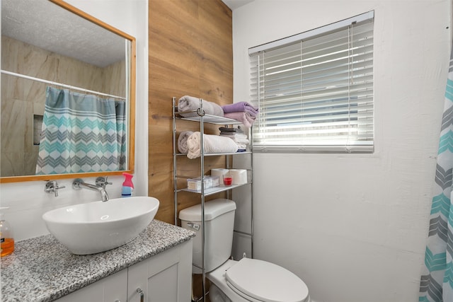 bathroom with wood walls, a shower with shower curtain, vanity, and toilet