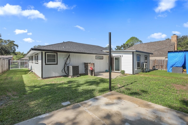 rear view of house featuring a yard, cooling unit, and a patio area