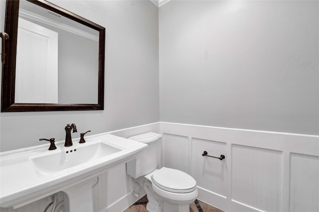 bathroom featuring ornamental molding, sink, and toilet