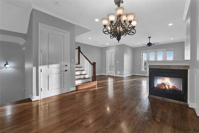 unfurnished living room with a multi sided fireplace, ceiling fan with notable chandelier, dark hardwood / wood-style flooring, and ornamental molding