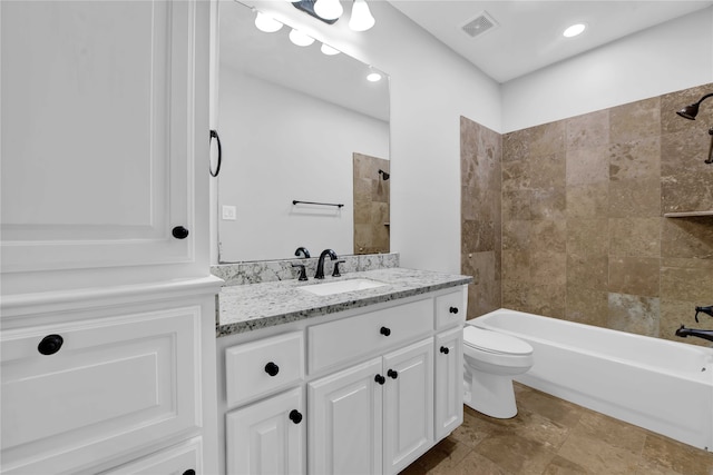 full bathroom with vanity, tiled shower / bath combo, and toilet