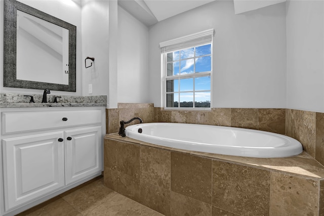 bathroom featuring tiled bath, vanity, and tile patterned floors