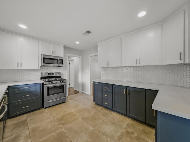 kitchen with white cabinets, light tile patterned floors, stainless steel appliances, and tasteful backsplash