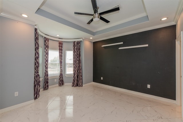 empty room featuring ceiling fan, a raised ceiling, and crown molding