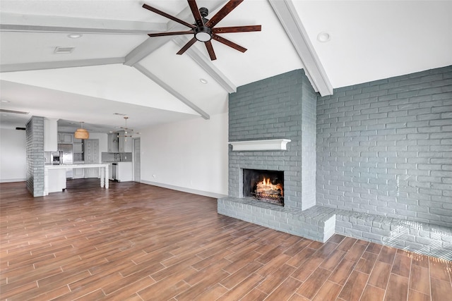 unfurnished living room with ceiling fan, lofted ceiling with beams, and a brick fireplace